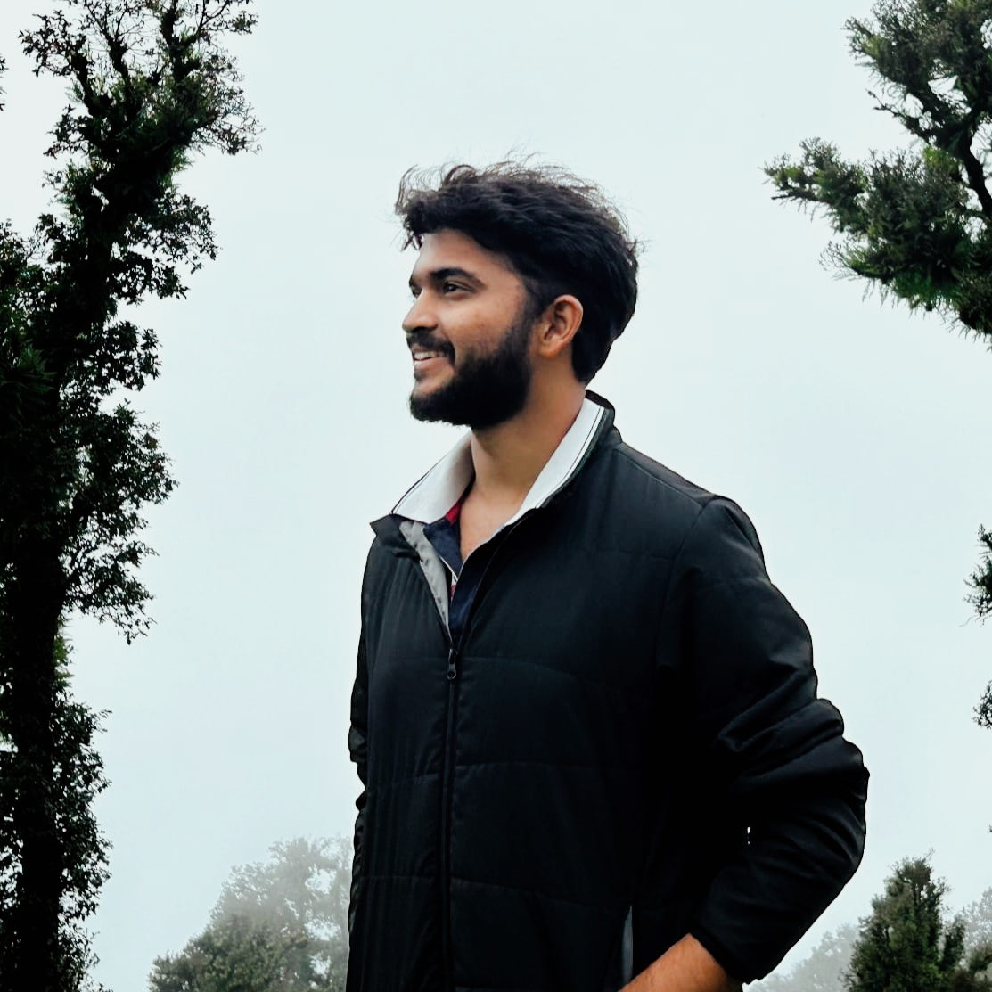 Portrait of Amogh, the founder and traveler behind TravAmogh, smiling in an outdoor setting