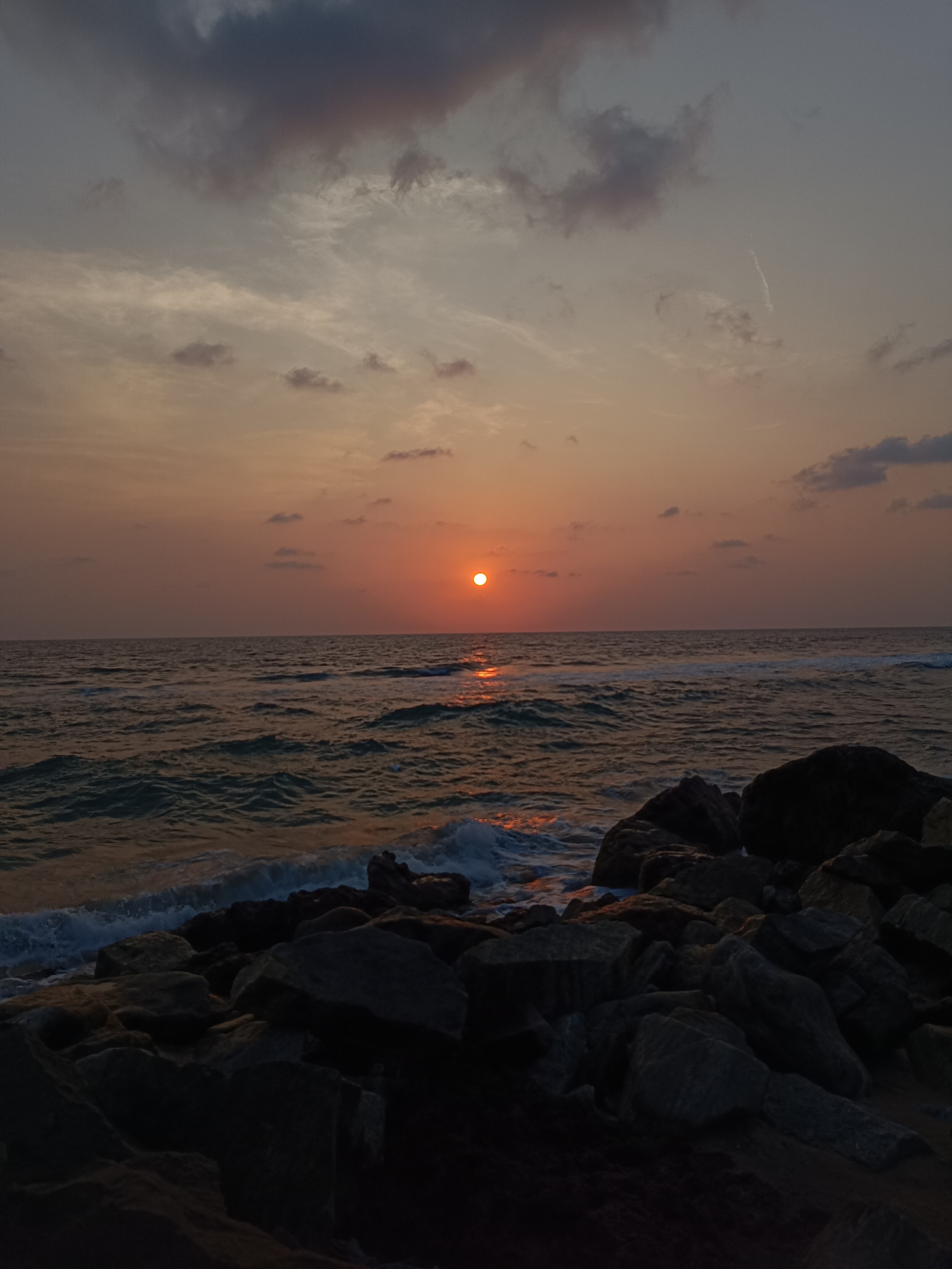 Sunset at Varkala beach with greenish sea water
