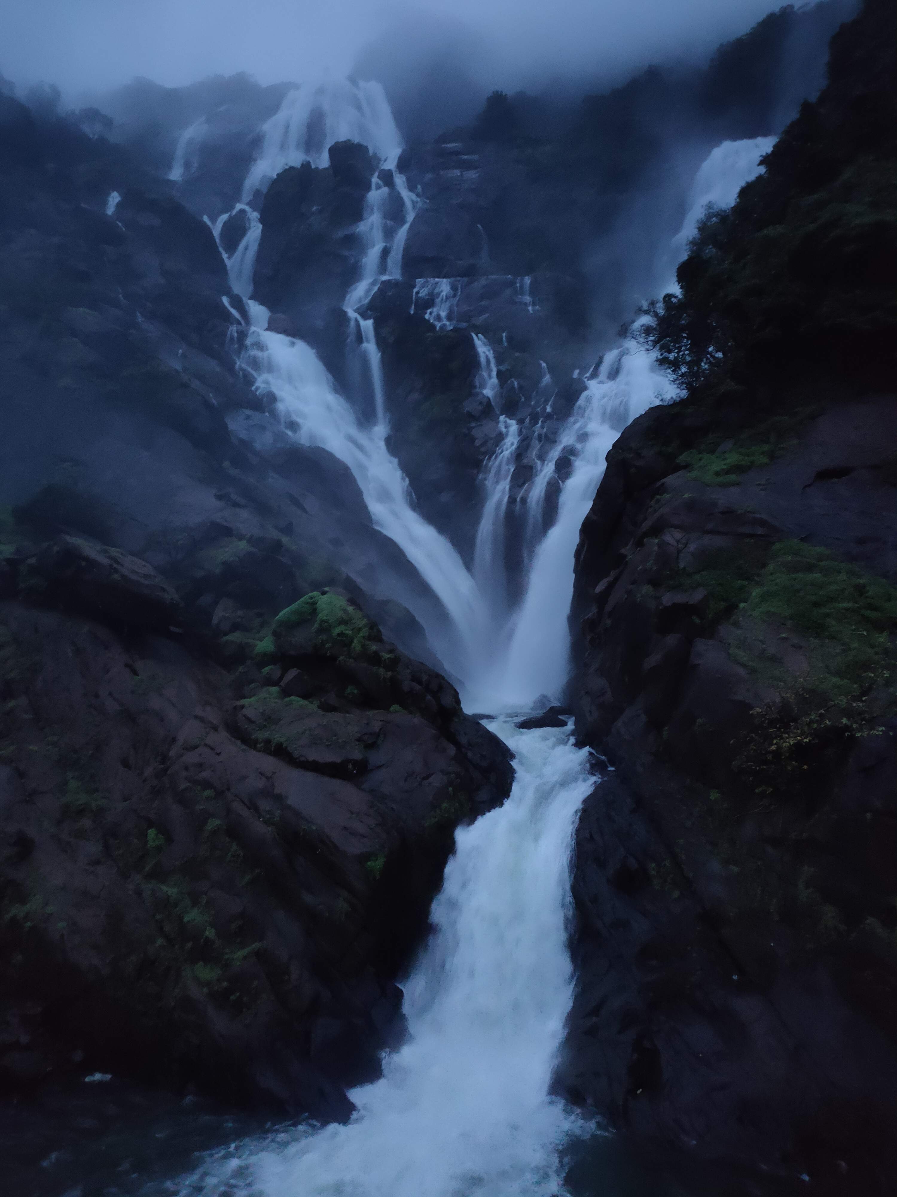Group of travelers taking photos at the base of Dudhsagar Waterfalls