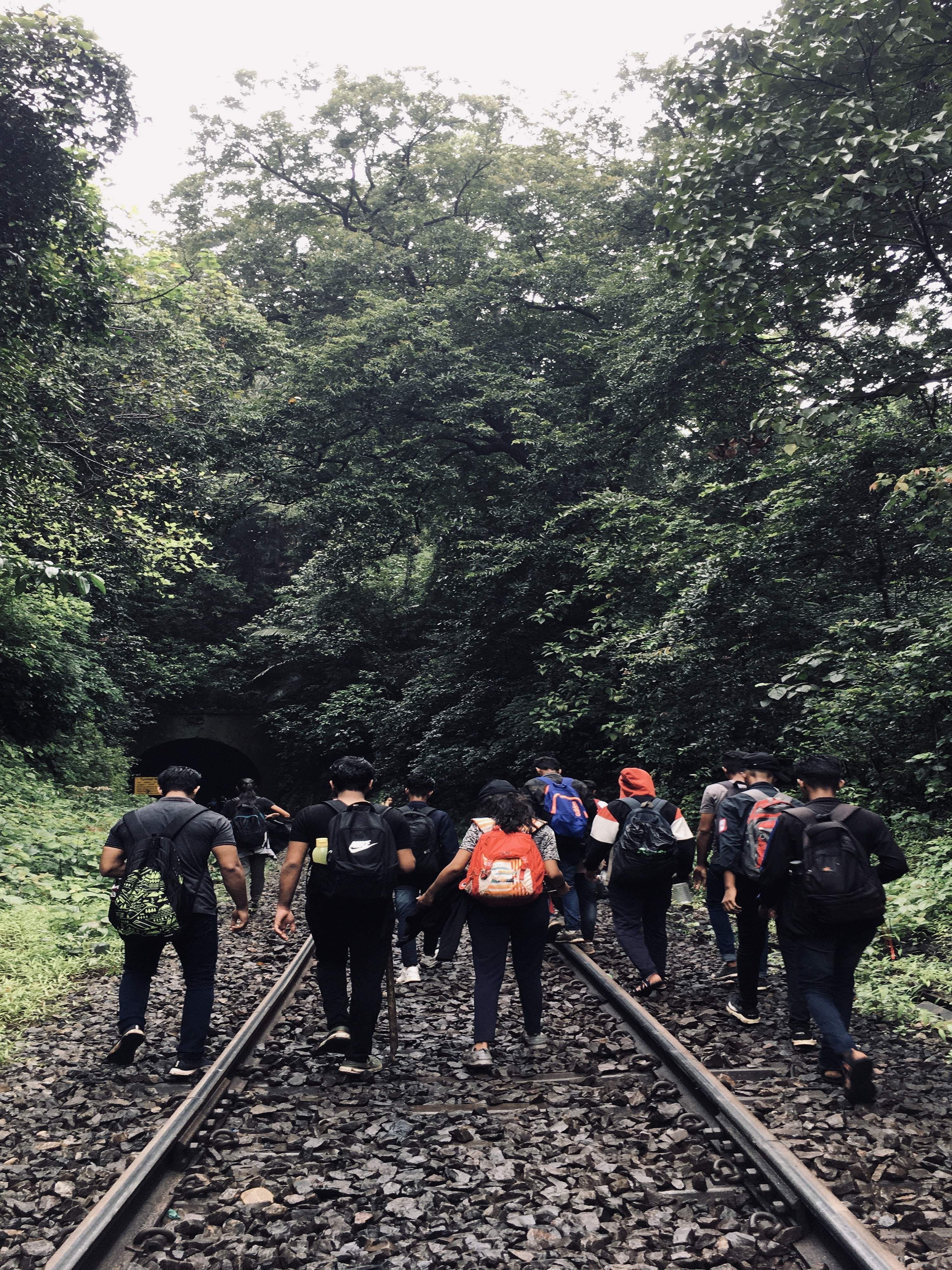 Travelers walking along the railway tracks towards Kulem station after visiting Dudhsagar