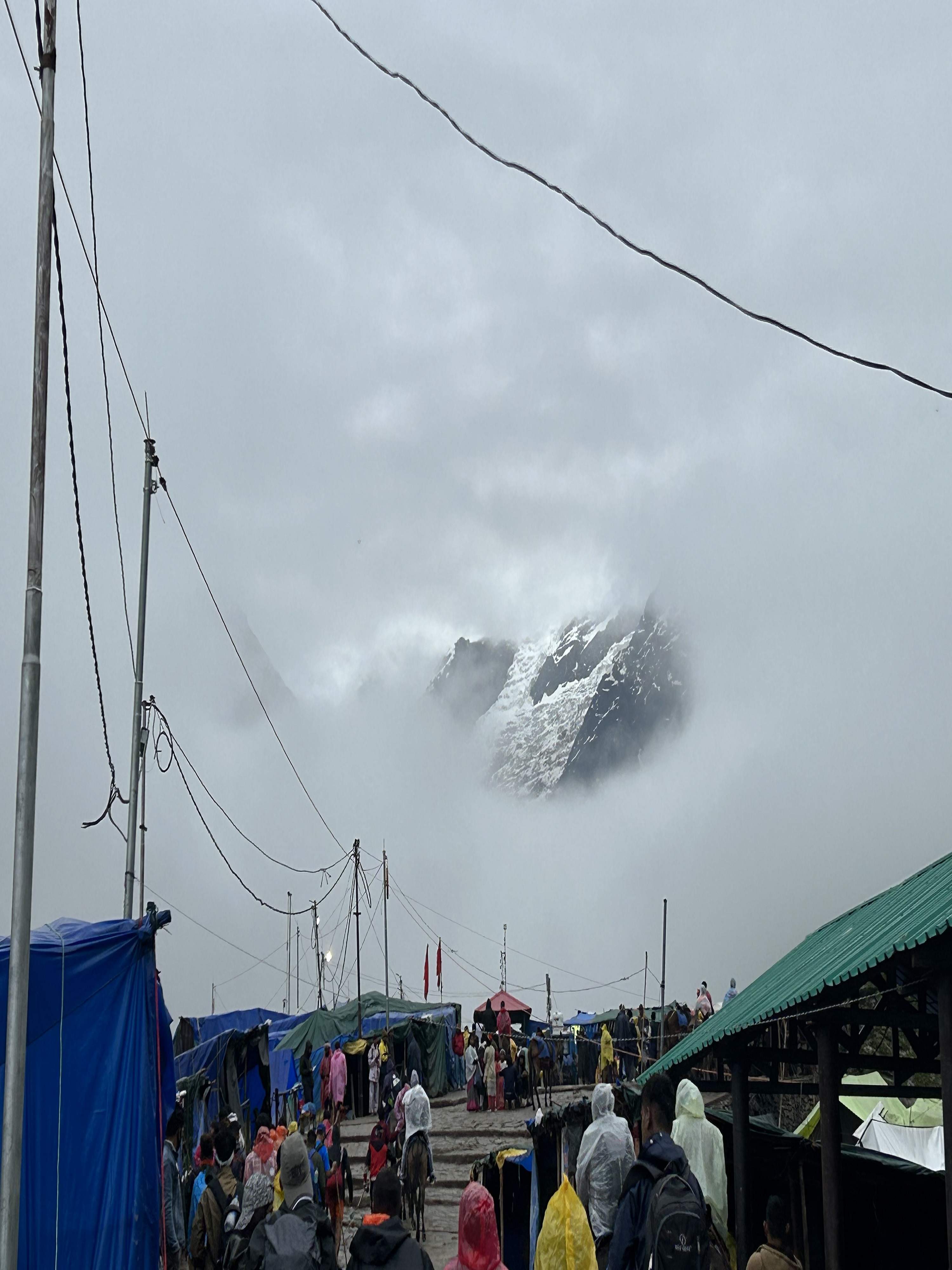 Sacred Kedarnath temple entrance with pilgrims in prayer