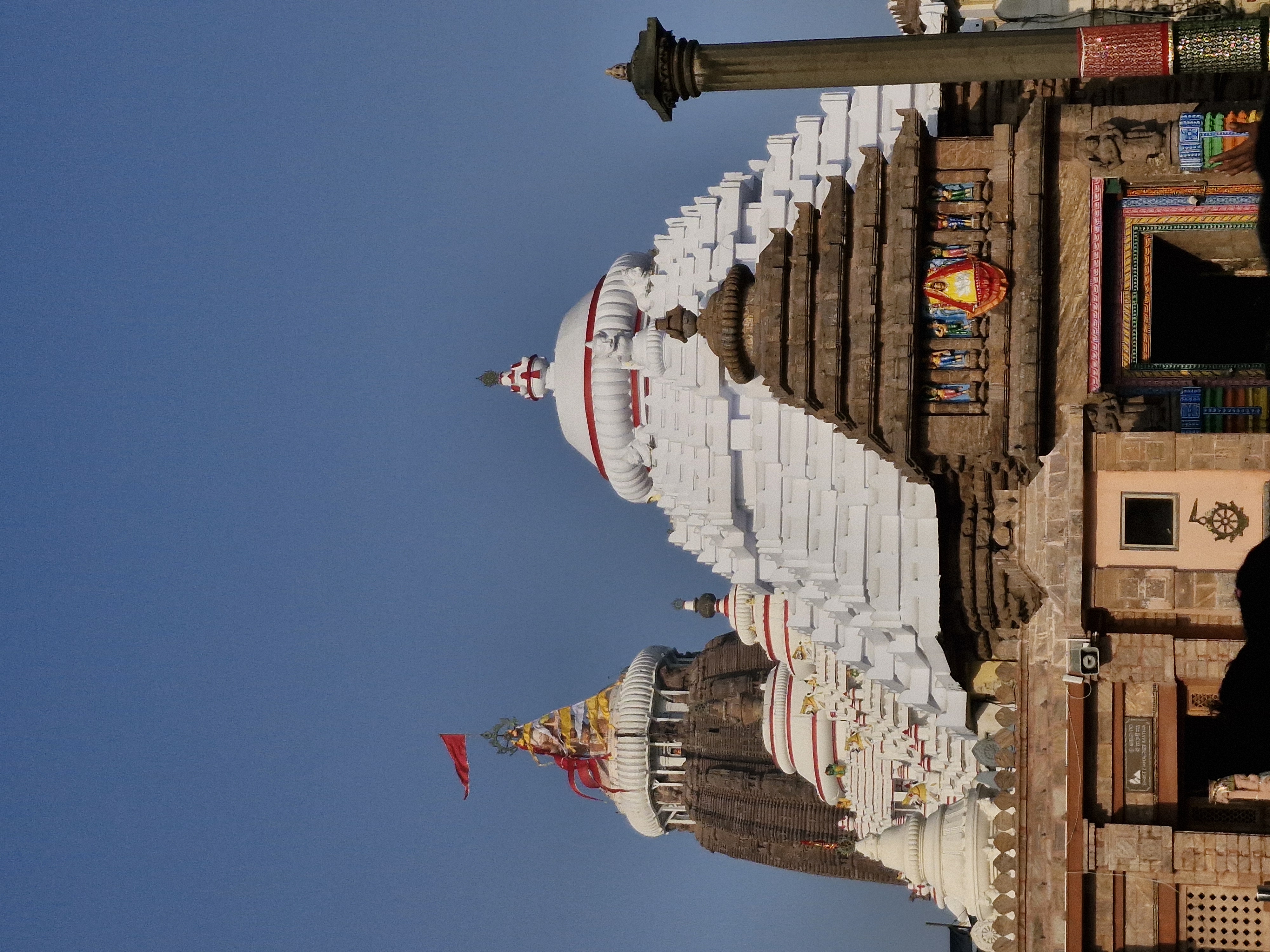 First glimpse of the illuminated Puri Jagannath Temple at night with orange flag