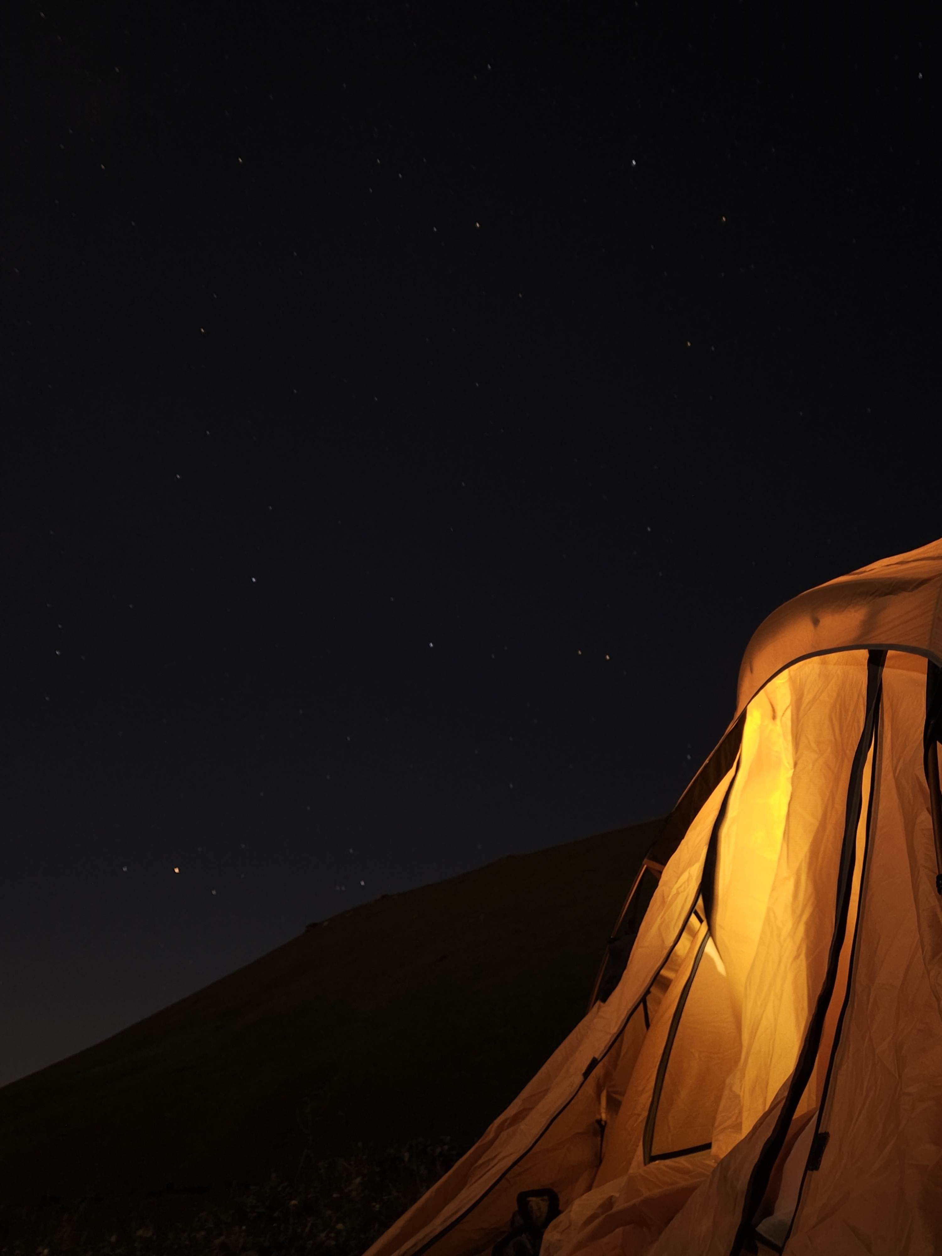 Dayara campsite with green mountains and blue sky
